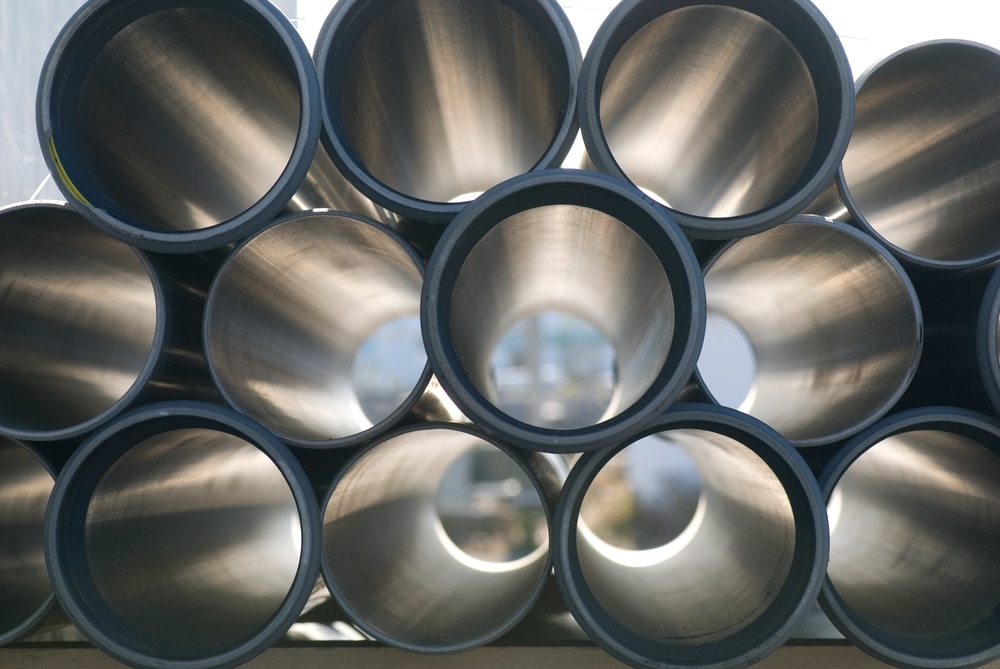 Stacked metal pipes viewed from the open ends, showing circular openings and reflective interiors